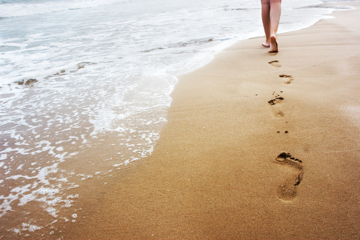 lopen op het strand met zichtbare voetstappen
